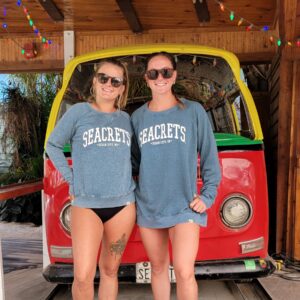 two women standing in front of a vw bus
