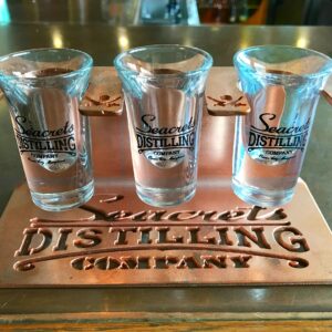 a set of four shot glasses sitting on top of a metal tray