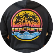 a man wearing a black hoodie with a sunset and palm trees on it