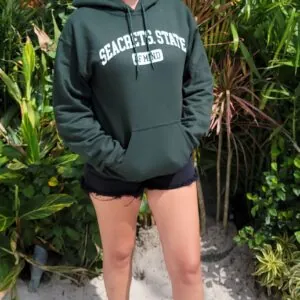 a woman wearing a green sweatshirt and shorts