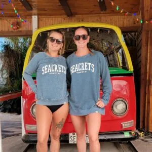 two women standing in front of a vw bus