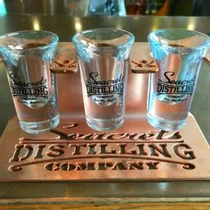 a set of four shot glasses sitting on top of a metal tray